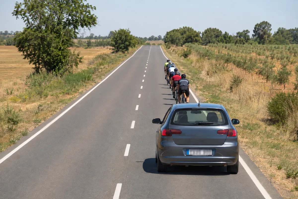Antes de salir, el coche sigue en su carril detrás de un grupo de ciclistas y el sentido contrario está libre un buen tramo.