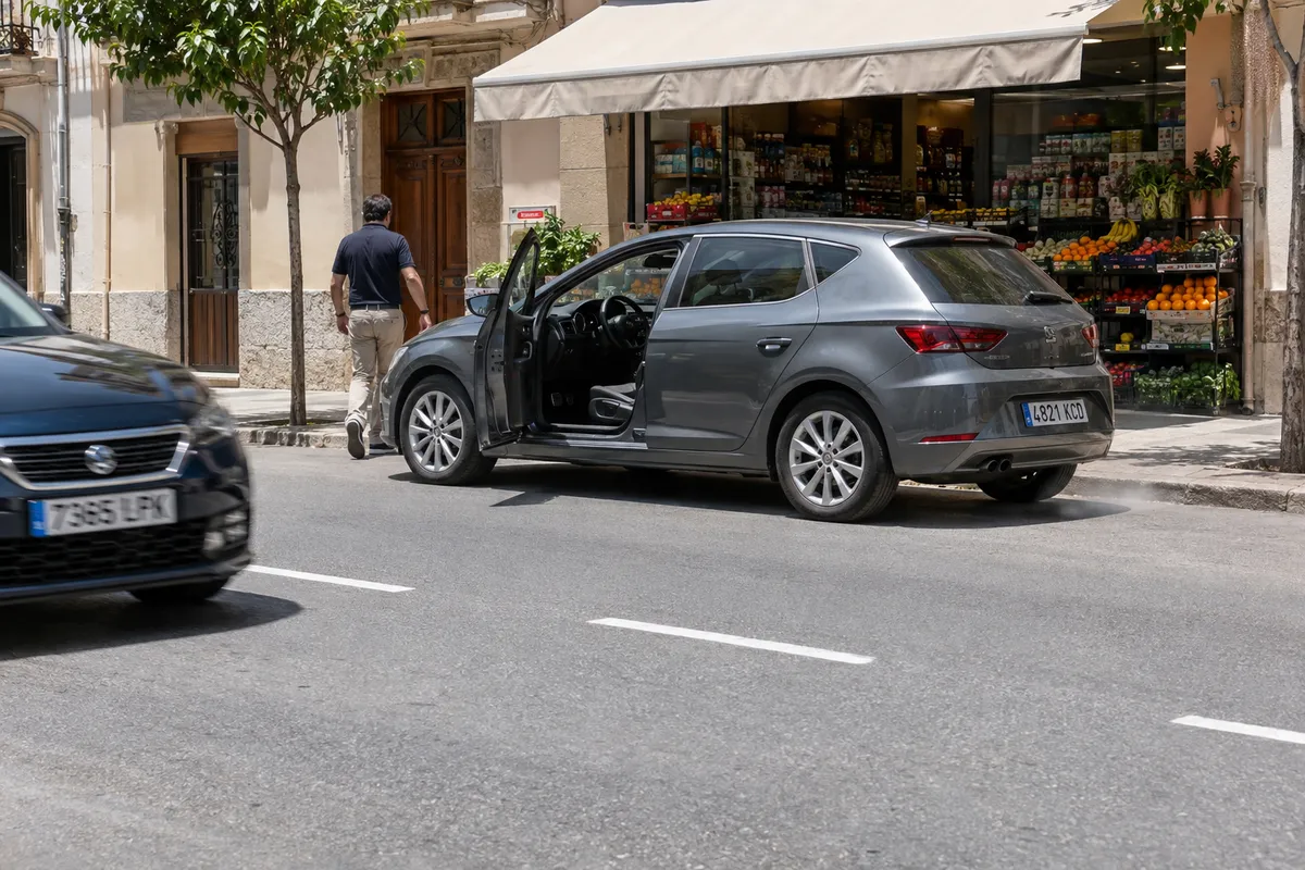 El conductor baja del coche con el motor en marcha para entrar en la tienda.