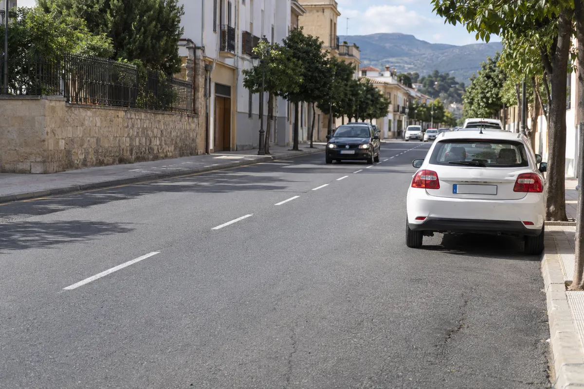 En una calle de doble sentido, el coche queda junto al bordillo derecho y el hueco está al otro lado.