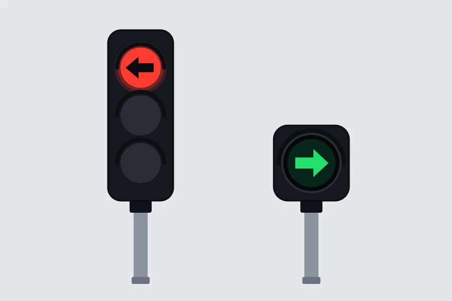 Un semáforo con una flecha negra sobre la luz roja y otro con una flecha verde sobre fondo circular negro