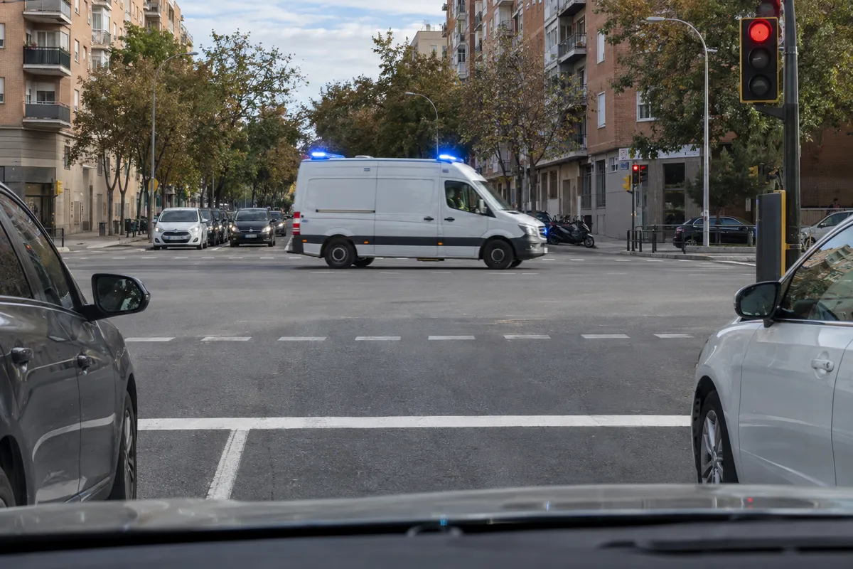 La ambulancia cruza cuando ha comprobado que los coches de los lados han parado o le dejan paso.