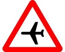 Señal: Aeropuerto: peligro por la proximidad de un lugar donde frecuentemente vuelan aeronaves a baja altura sobre la vía y que pueden originar ruidos imprevistos