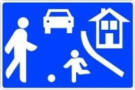 Señal: Zona de estancia y juego: zona destinada en primer lugar a los peatones; velocidad máxima de 10 km/h, prioridad de los peatones, juegos y deportes autorizados