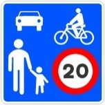Señal: Zona de coexistencia: circulación compartida con prioridad peatonal y máximo de 20 km/h; peatones en toda la zona, sin pasos señalizados; ciclos y, en su caso, vehículos de movilidad personal en ambos sentidos salvo decisión contraria de la autoridad; estacionamiento en lugares designados; juegos y deportes no autorizados.