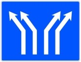 Señal: Bifurcación en calzada de cuatro carriles: en una calzada con cuatro carriles en el mismo sentido, se producirá una bifurcación con cambio de dirección de dos carriles hacia la izquierda y dos hacia la derecha